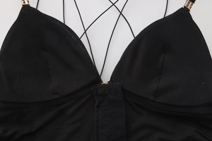 Dettaglio reggiseno nero con scollo a V, fibbie metalliche dorate e spalline sottili