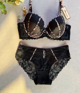 Set di lingerie in pizzo nero con bordi leopardati su sfondo grigio testurizzato