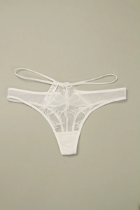 Détail de string en dentelle blanche avec broderie florale et doubles lanières