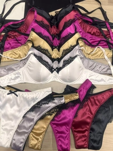 Detailed flat lay of satin and lace lingerie sets in multiple colors on wooden background
