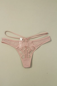 Détail de broderie papillon sur ce string rose poudré avec double lanière