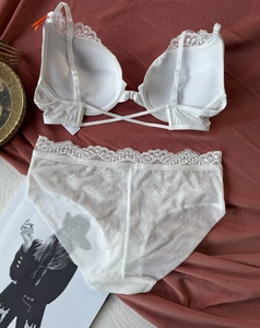 Lace lingerie set with front-closure bra and sheer mesh panties on a dark background