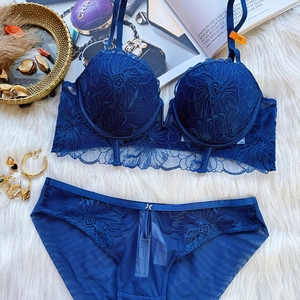 Detailed view of dark blue lace lingerie set with floral embroidery on white faux fur