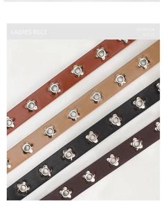 Parallel layout of four leather belts with decorative petal shaped silver metal eyelets