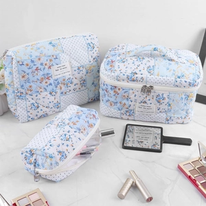 Detailed set of three floral quilted makeup bags with handle in varying sizes