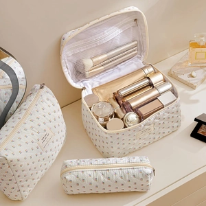 Three-piece set of floral quilted makeup bags with internal organizers and brush slots