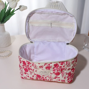 Detailed view of floral quilted cotton makeup bag featuring mesh inner zip compartment