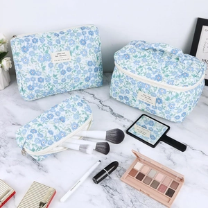 Three-piece quilted floral cosmetic bag set with zipper and embroidered label
