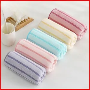 Close-up of five colorful striped coral fleece hair towels for girls in a bathroom set