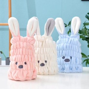 Close-up of soft coral fleece hair towels featuring cute bunny ears in pink, white, and blue