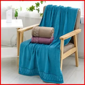 Detailed view of plush coral fleece towels with elegant diamond jacquard edge texture