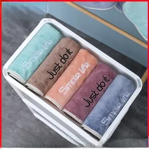 Close-up of five-color microfiber hair towels with embroidery in a storage basket
