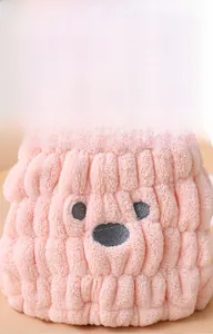 Detailed close-up of soft pink coral fleece fabric with a cute embroidered bear face