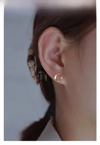 Close-up of 14K gold plated silver crescent moon stud earring with a small zircon stone