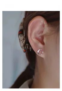 Close-up of S925 sterling silver crescent moon stud earring with a tiny sparkling zircon