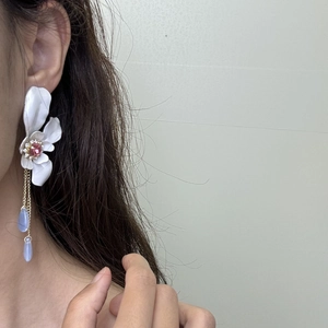 Elegant long tassel earrings with white flowers and pink gemstones on model