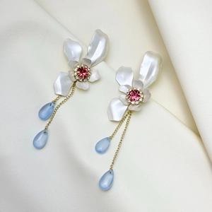 Detail of floral drop earrings with pink center stone and blue teardrop charms
