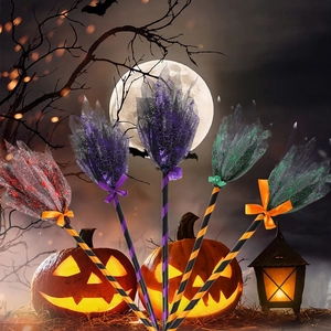 Detail of five colorful Halloween witch brooms with spider web mesh and LED pumpkin background