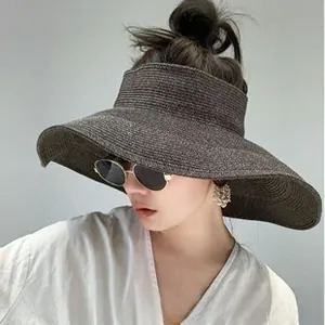 Detail of a deep coffee straw sun hat with wide brim and fine woven texture