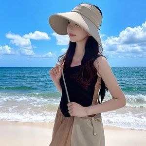 Detail of beige wide brim sun visor hat with delicate texture on a sunny beach
