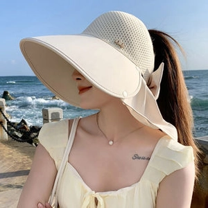Detail view of beige wide-brim sun hat with breathable mesh top and elegant bow ribbon