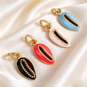 Macro view of shell-shaped alloy pendants with colorful enamel coating and golden bead detail