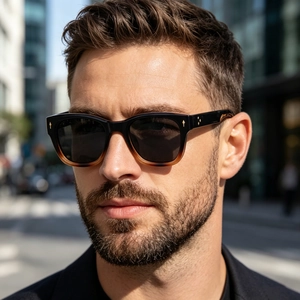 Close-up of polarized square sunglasses with black to brown gradient frames and gold accents