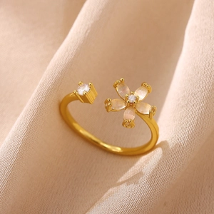 Detail of adjustable flower ring with opal petals and sparkling zircon on silk background