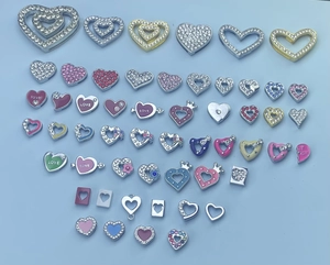 Flat lay of colorful enamel heart charms and rhinestone love beads for DIY jewelry