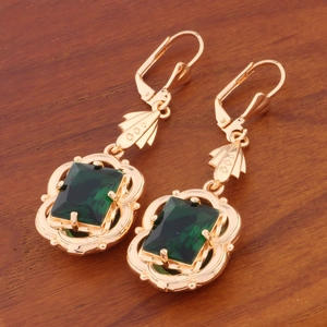 Detailed close-up of vintage leverback earrings with rectangular green crystal accents