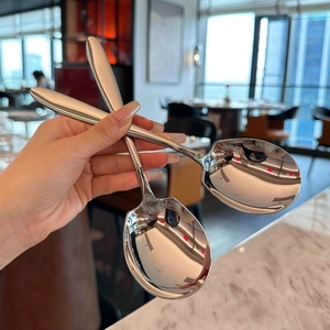 Macro shot of polished thick stainless steel serving spoon with mirror finish surface
