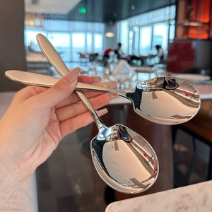 Close-up of thick stainless steel serving spoon with polished mirror finish and wide head