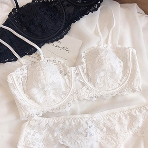 Detail of floral lace texture on white and black bras with scalloped edge design
