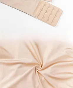 Detail of nude strapless bra showing wide non-slip side wings and secure back hook closure
