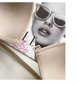 Detail of seamless nude bra with adjustable strap and refined stitching on smooth fabric
