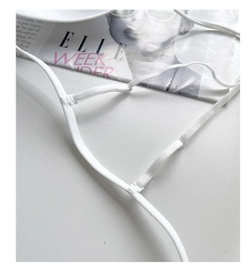 Detail shot of white seamless bra straps with adjustable sliders and fine stitching