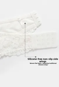 Detail of white lace bra featuring non-slip side wings and wide four-row hook closure