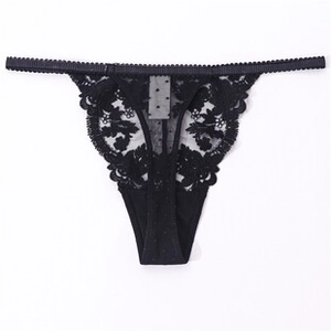 Dettaglio ravvicinato del pizzo floreale nero e del mesh a pois trasparente sullo slip