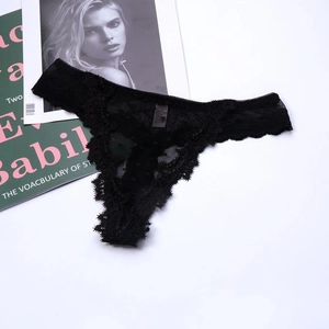 Detailed view of black floral lace thong with delicate scalloped edges and sheer texture