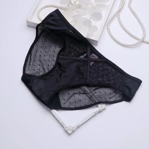Detailed view of black satin lace panties with criss-cross straps and mesh texture