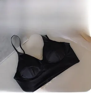Détail d'un soutien-gorge en satin noir avec bonnets triangles et fines bretelles
