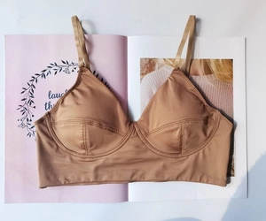Detailed flat lay of brown wireless triangle bralette on a magazine with thin straps