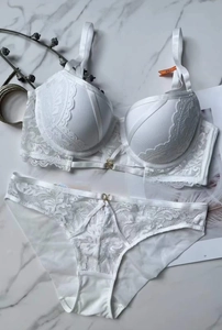 Vista piatta di un set di lingerie in pizzo bianco con reggiseno push-up e slip abbinati