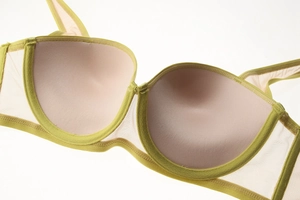 Dettaglio del reggiseno verde lime con coppe rosa e ali laterali in rete traspirante