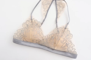 Dettaglio ricamo floreale su bralette in mesh trasparente con schiena incrociata