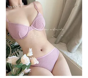 Macro detail of pink waffle-textured lace bra set featuring adjustable straps and wiring