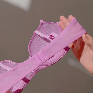 Close-up of pink lace bra featuring breathable honeycomb mesh fabric and elastic side band