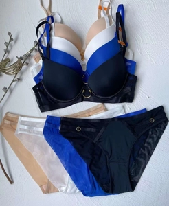 Detailed flat lay of seamless lace lingerie sets with elegant gold ring hardware details
