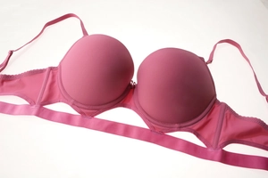 Detail of rose pink seamless push-up bra featuring hollow-out side wings and thin straps