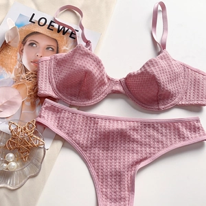 Detail view of light pink waffle texture bra and thong set on a minimalist background